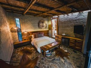 a bedroom with a bed and a flat screen tv at Element Quindío in Boquía