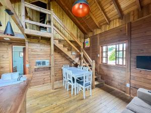 ein Esszimmer in einem Blockhaus mit einem Tisch und Stühlen in der Unterkunft Arte da Tribo Hostel & Camping in Praia do Rosa
