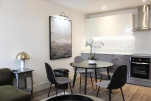 チェルムスフォードにある2 Bed Apartment, Free Parking, Chelmsford City Centre, with Sky Sports, Movies and Netflixのテーブルと椅子のあるキッチンとダイニングルーム