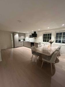 una cucina con un tavolo e sedie in una stanza di 2 hytter i sjøkanten med 20 sengeplasser a Kristiansand