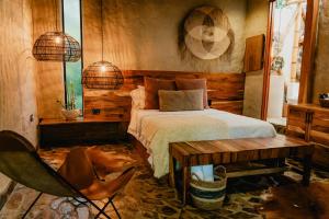 a bedroom with a bed and a table and a chair at Element Quindío in Boquía