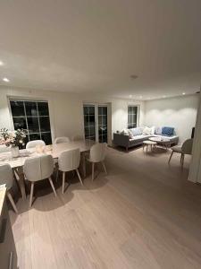 un soggiorno con tavolo, sedie e divano di 2 hytter i sjøkanten med 20 sengeplasser a Kristiansand