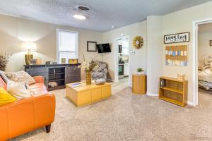 a living room with an orange couch and a table at Pueblo Perfection A Quiet Colorado Adventure! in Pueblo