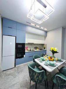 a dining room with a table and chairs and a kitchen at Rich Life in Almaty