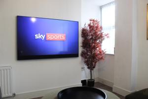 チェルムスフォードにある2 Bed Apartment, Free Parking, Chelmsford City Centre, with Sky Sports, Movies and Netflixのクリスマスツリーの壁に薄型テレビが付いています。