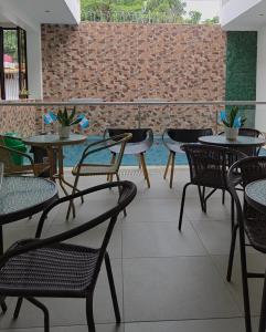 a patio with tables and chairs and a brick wall at Casa Sismarro Hotel in Retalhuleu