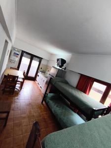 a living room with a green couch and a kitchen at El Dorado Deptos a una cuadra del mar in San Bernardo
