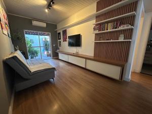 ein Wohnzimmer mit Fernseher, Couch und Tisch in der Unterkunft Casa Flor - Ribas do Rio Pardo in Ribas do Rio Pardo