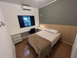 ein kleines Schlafzimmer mit einem Bett und einem Fenster in der Unterkunft Casa Flor - Ribas do Rio Pardo in Ribas do Rio Pardo + 13 Fotos