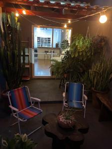 2 Stühle und ein Tisch in einem Zimmer mit Pflanzen in der Unterkunft Casa Flor - Ribas do Rio Pardo in Ribas do Rio Pardo