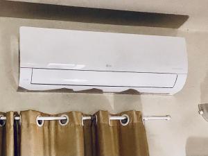 a television on a wall above a shower curtain at Chalé do Vale à 10 min de carro de Itacoatiara in Niterói +20 photos