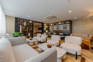 a waiting room with white chairs and tables at Hotel Límade in Lima