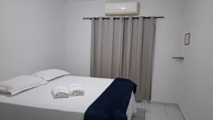 a white bed with two pillows on top of it at Apt perto do shopping in Petrolina