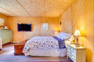 ein Schlafzimmer mit einem Bett und einem Fernseher in der Unterkunft Hike, Ski and Golf Water-View Lake Winola Retreat! in Factoryville