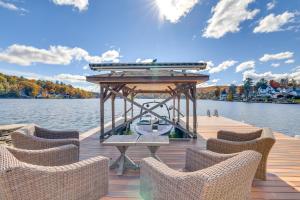 a wooden dock with chairs and a table on the water at Scenic Waterfront Home with Dock on Lake Winola! in Factoryville