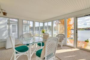 a dining room with a table and chairs and windows at All-Season Getaway on Lake Winola Dock and Sunroom! in Factoryville