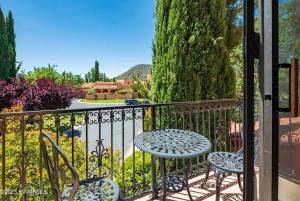 ein Balkon mit einem Tisch und Stühlen auf einem Zaun in der Unterkunft Celestial Citadel-Great Views Year Round in Oak Creek