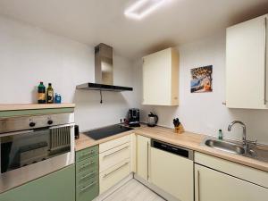 Spacious 72 sqm Moselblick apartment & top connection في ترير: مطبخ بخزائن بيضاء ومغسلة