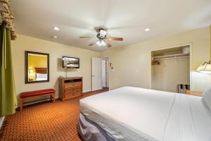 ein Schlafzimmer mit einem Bett und einem Deckenventilator in der Unterkunft Pine - Lodge - Roundhouse Resort and Spa in Indian Pine