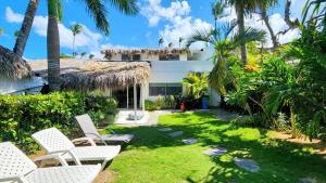 ein Hof mit weißen Stühlen und Palmen in der Unterkunft BEACH FRONT 3 Bedroom Villa with Pool Sleeps 7 in Las Terrenas