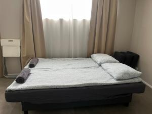 a bed with two pillows and a window in a room at Ary & Pablo Airport Stay in Keflavík