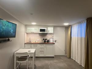 a kitchen with a table and a tv on the wall at Ary & Pablo Airport Stay in Keflavík +8 photos