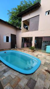 a large blue pool in front of a house at Hotel Acácia in Tangara da Serra