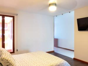 a bedroom with a bed and a tv on a wall at Acogedor Loft en centro histórico - Depa #2 in Isla Cardones