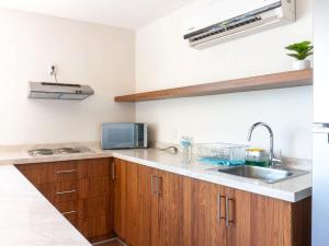 a kitchen with wooden cabinets and a sink at Acogedor Loft en centro histórico - Depa #2 in Isla Cardones