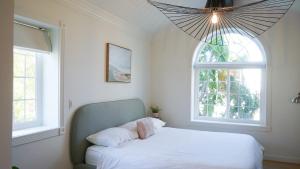 a bedroom with a white bed and a window at Modern European Townhouse in Vista