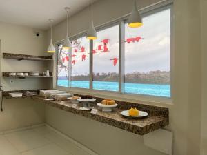 a kitchen with a window with a view of the ocean at Vila Mar Eco Hotel in Parnaíba