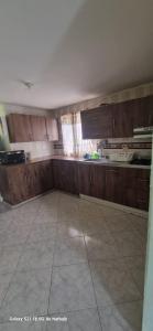 een lege keuken met houten kasten en een tegelvloer bij Finca El Paraíso in Villeta