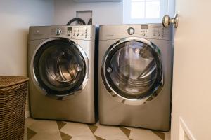 two washing machines and a dryer in a room at Modern European Townhouse in Vista