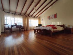 a large bedroom with a bed and a wooden floor at Hotel Qhawarina de Casas Kolping Bolivia S.R.L. in Sucre