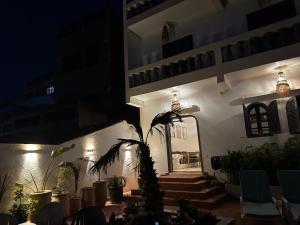 a building with a potted plant and stairs at night at À Unique villa, 4 rooms, 5 beds , entire house, LEGZIRA Beach in Sidi Ifni
