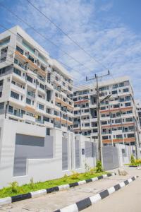 a large white apartment building in front of a street at Pwj Realty Apartments in Lekki