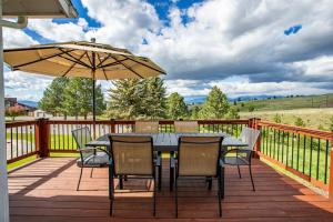 a table and chairs with an umbrella on a deck at Modern Home with Mountain Views in Missoula