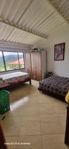 een slaapkamer met twee bedden en een groot raam bij Finca El Paraíso in Villeta +12 foto's