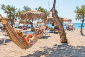 una donna sdraiata su un'amaca in spiaggia di Sun Beach Lindos a Lárdos