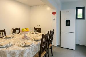 a dining room table with a bowl of fruit and a refrigerator at Casa Joao Batista em Machico in Machico
