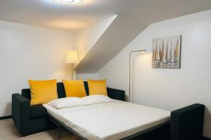 a bed in a room with yellow pillows at Casa Joao Batista em Machico in Machico +8 photos