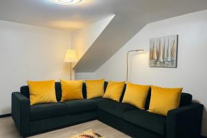a black couch with yellow pillows in a living room at Casa Joao Batista em Machico in Machico