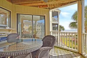 a patio with a table and chairs on a balcony at PC202E: 202E Port O'Call in Isle of Palms