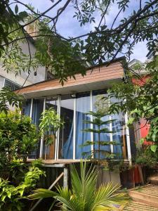 a window of a house with a blue curtain at Dalat inn homestay hẻm 48 hà huy tập in Teurnoum