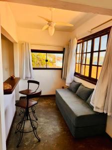 a living room with a couch and a table and windows at Pousada Azul do Mar in Búzios