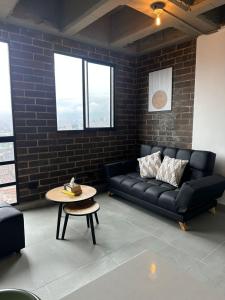 サバネタにあるSabaneta Parque, Wifi,Excelente vista ,Centralの黒いソファとテーブルのあるリビングルーム