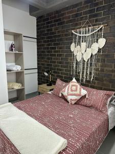 サバネタにあるSabaneta Parque, Wifi,Excelente vista ,Centralのベッドとレンガの壁がある寝室