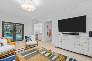 a living room with a flat screen tv on a white cabinet at Deep Blue Waterfront Gem Pool Kayaks Dock in Key Colony Beach +65 photos