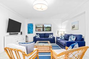 a living room with a blue couch and a tv at Deep Blue Waterfront Gem Pool Kayaks Dock in Key Colony Beach