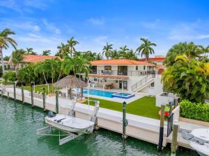 a house on the water with a boat on a dock at Deep Blue Waterfront Gem Pool Kayaks Dock in Key Colony Beach
